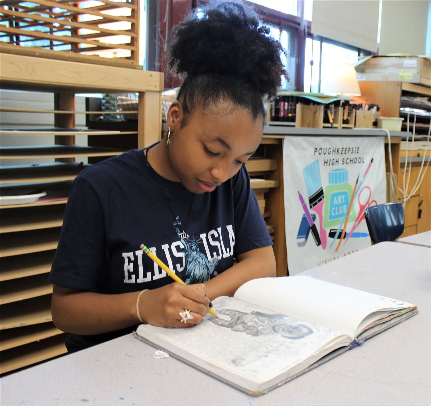  Junior Maelia Vasquez works on a sketch in her art book